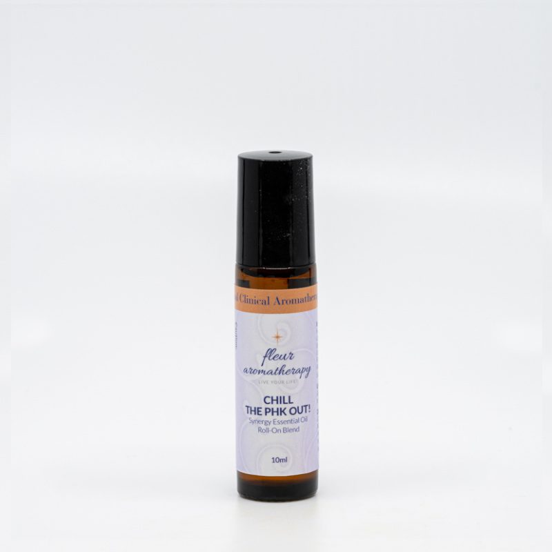 A roll on bottle of essential oil sitting next to a white wall.