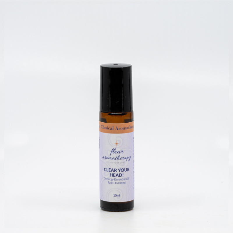A roll on bottle of essential oil sitting next to a white wall.
