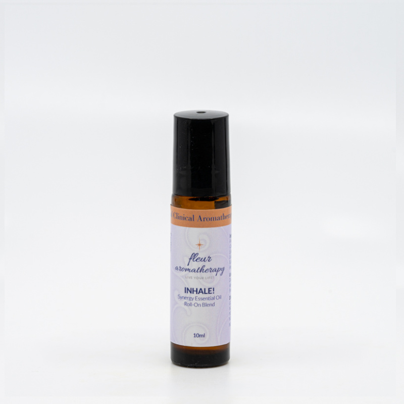 A roll on bottle of essential oil sitting next to a white wall.