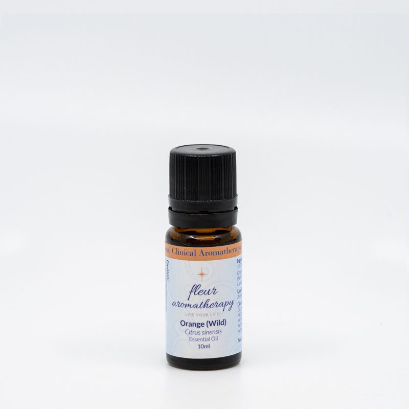 A bottle of orange essential oil on top of a white table.