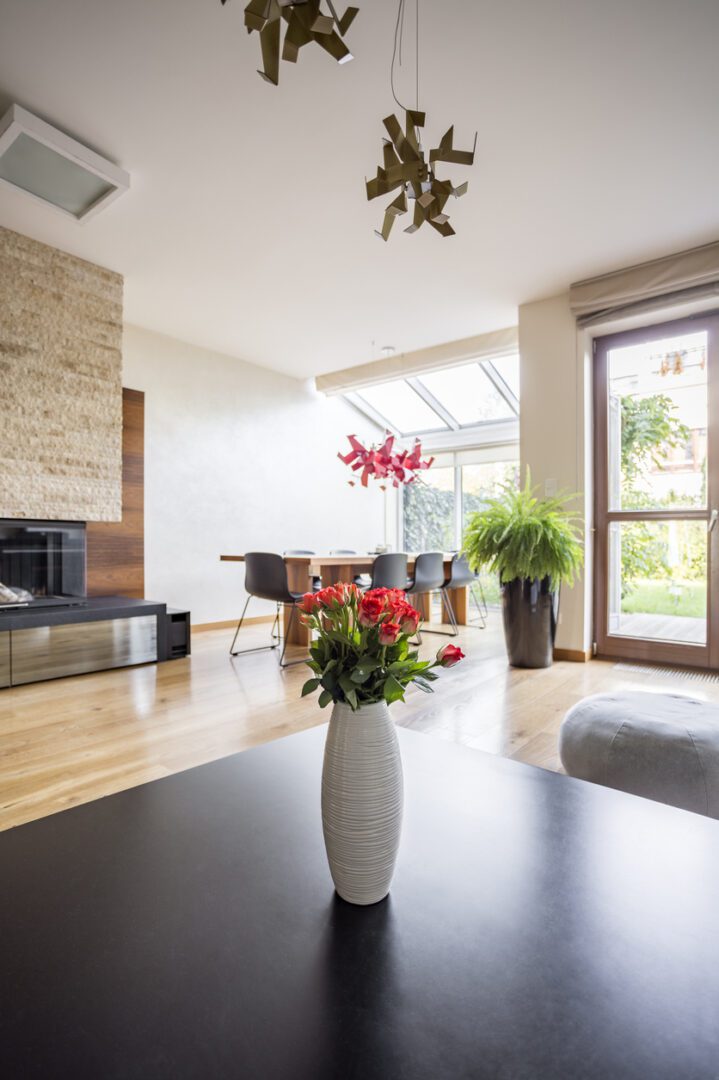 Close-up of vase with flowers on a wooden coffee table in lounge