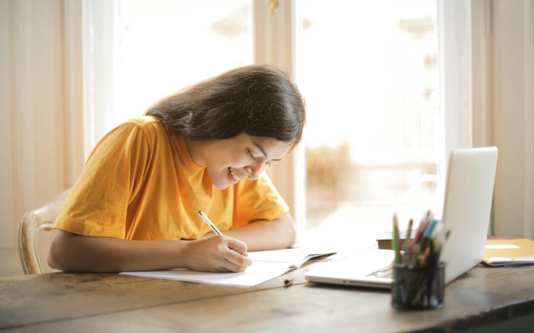Girl studying and writing at a desk.